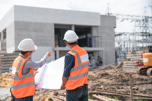 Construction engineers discussion with architects at construction site